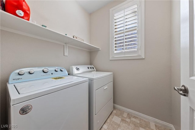 clothes washing area with laundry area, washing machine and dryer, and baseboards