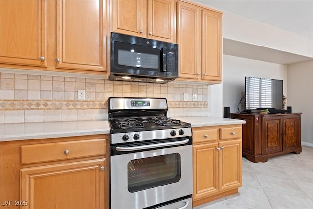 kitchen with stainless steel range with gas cooktop, black microwave, backsplash, and light tile patterned floors