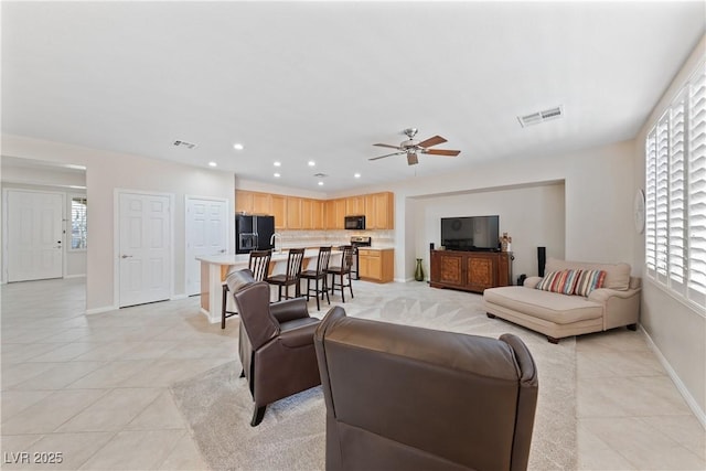 living area with light tile patterned floors, recessed lighting, visible vents, ceiling fan, and baseboards