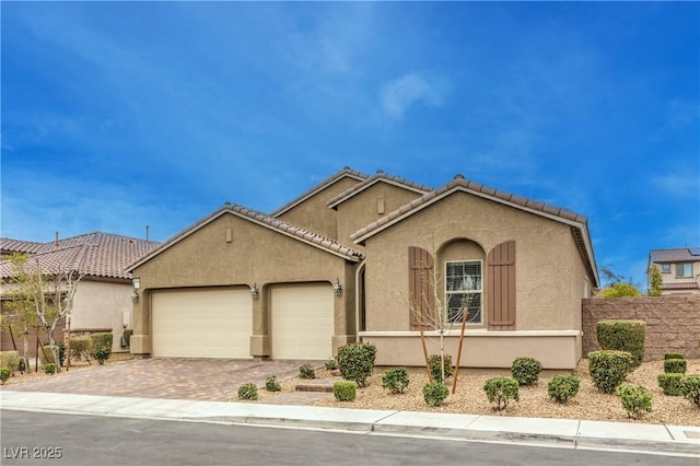 mediterranean / spanish-style house featuring driveway, a tiled roof, an attached garage, fence, and stucco siding