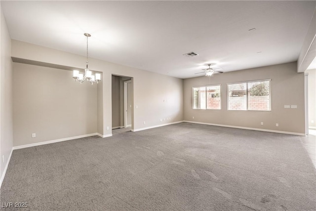 carpeted spare room with visible vents, baseboards, and ceiling fan with notable chandelier