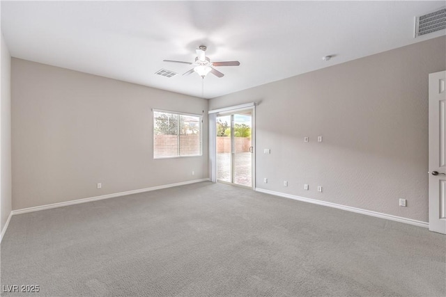 unfurnished room featuring carpet floors, baseboards, visible vents, and a ceiling fan