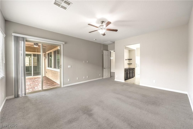 carpeted empty room featuring visible vents, ceiling fan, and baseboards