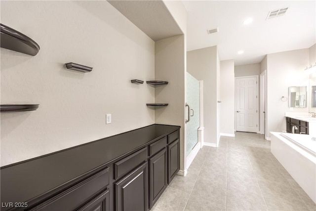 bathroom featuring vanity, baseboards, visible vents, tile patterned floors, and a stall shower