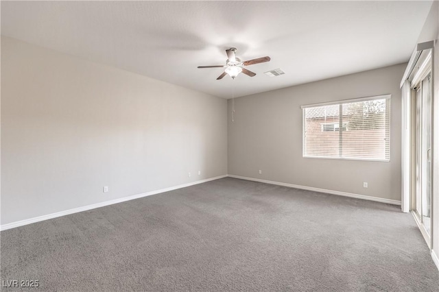 carpeted spare room with ceiling fan, visible vents, and baseboards