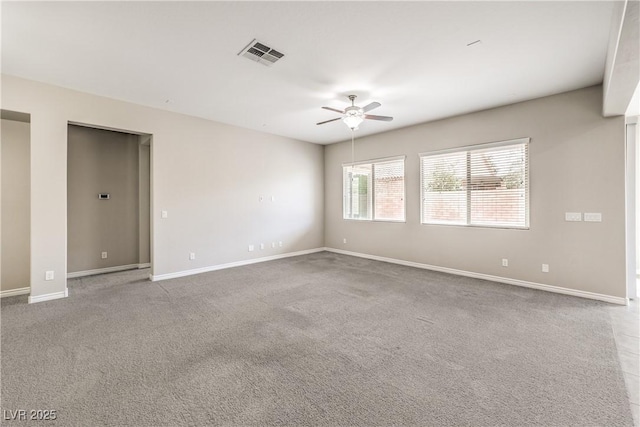 spare room featuring carpet, baseboards, visible vents, and ceiling fan