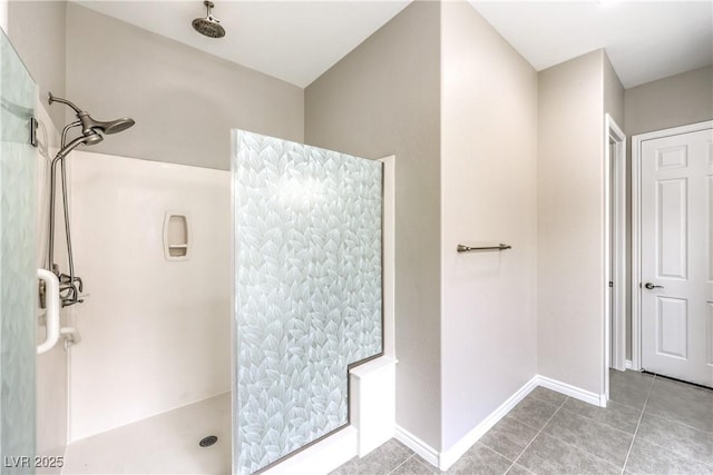 full bath featuring baseboards, a walk in shower, and tile patterned floors