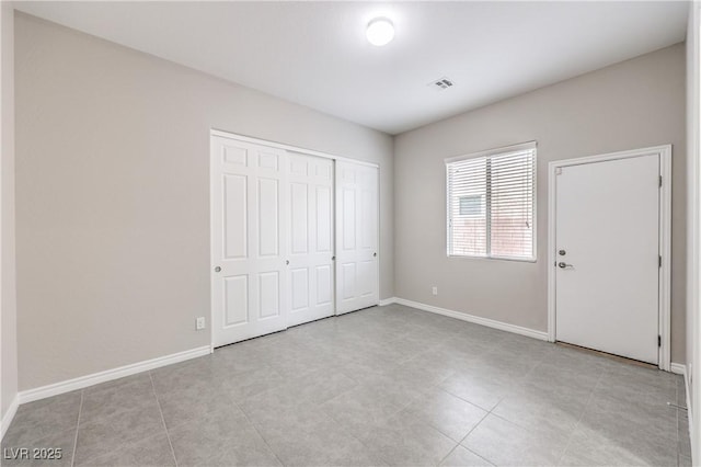 unfurnished bedroom featuring visible vents, baseboards, and a closet