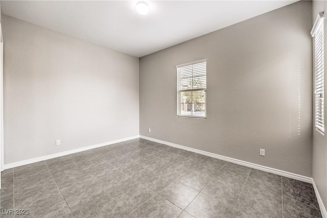 unfurnished room with baseboards