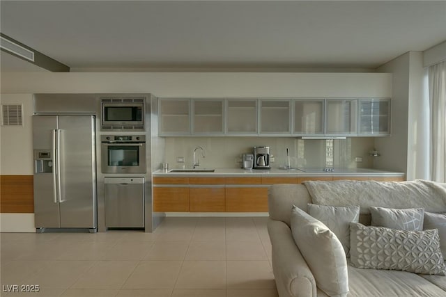 kitchen with a sink, visible vents, open floor plan, light countertops, and appliances with stainless steel finishes