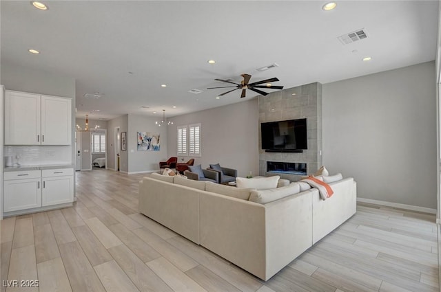 living room with light wood-type flooring, plenty of natural light, visible vents, and recessed lighting