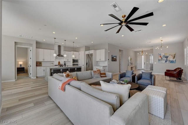 living room featuring light wood-type flooring, visible vents, baseboards, and recessed lighting