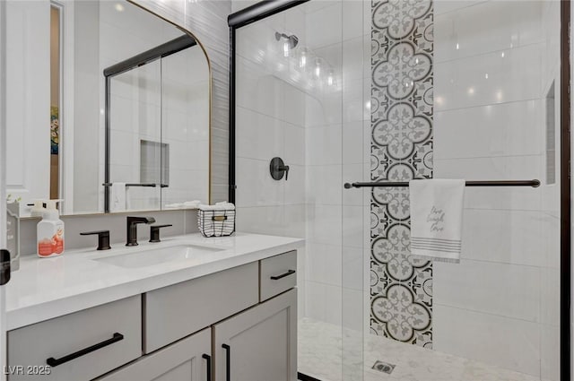 full bath featuring a tile shower and vanity