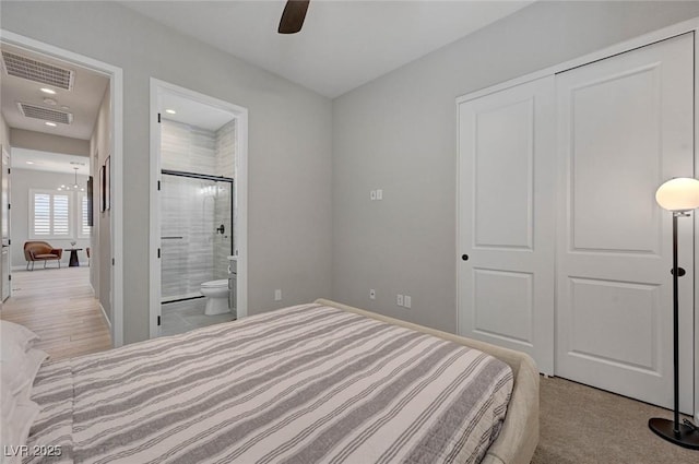 bedroom featuring baseboards, ensuite bath, visible vents, and a closet