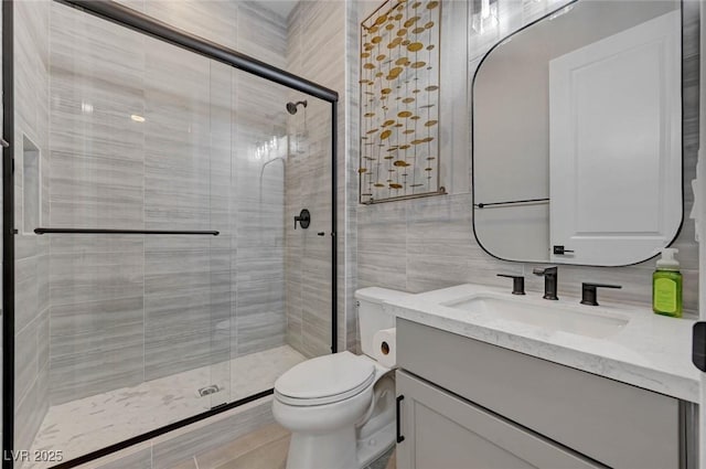 full bathroom featuring toilet, a shower stall, vanity, and tile walls