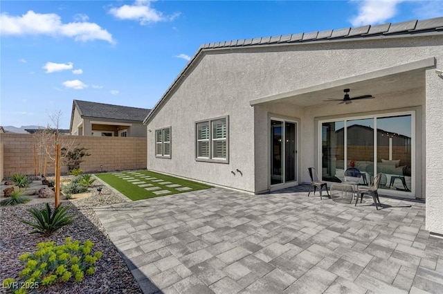 back of property featuring a patio area, fence, a ceiling fan, and stucco siding