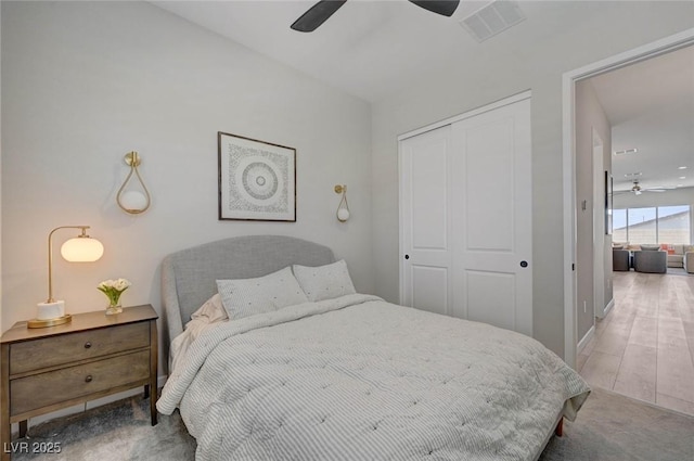 bedroom featuring baseboards, visible vents, ceiling fan, wood finished floors, and a closet