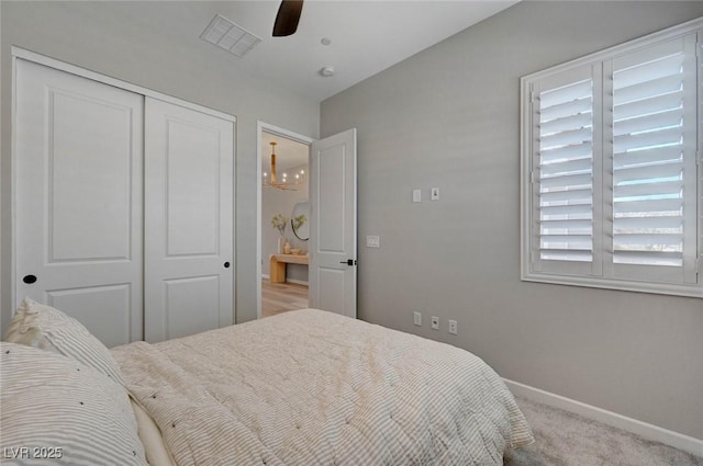 bedroom with carpet floors, a ceiling fan, visible vents, baseboards, and a closet