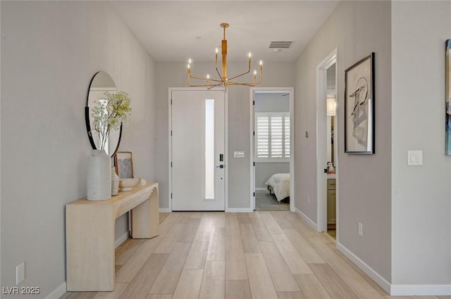 entryway featuring light wood-type flooring, visible vents, and baseboards