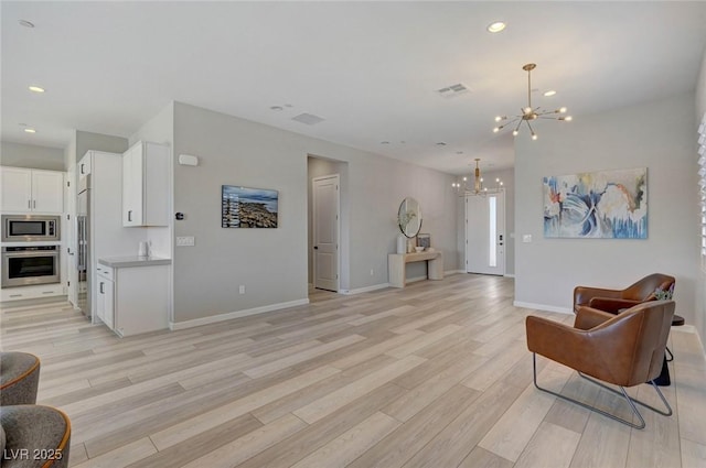 sitting room with light wood-style floors, recessed lighting, visible vents, and a notable chandelier