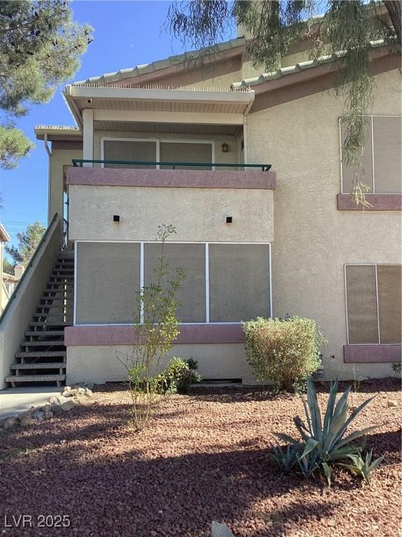 exterior space featuring stairway and stucco siding