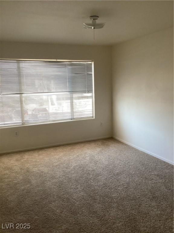 carpeted empty room with baseboards