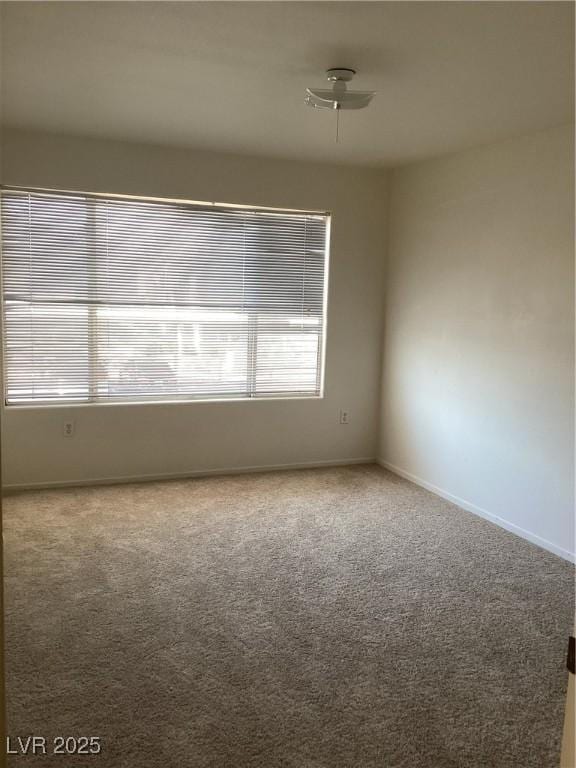 carpeted empty room with baseboards