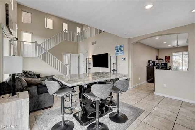 kitchen featuring visible vents, recessed lighting, arched walkways, light tile patterned flooring, and baseboards