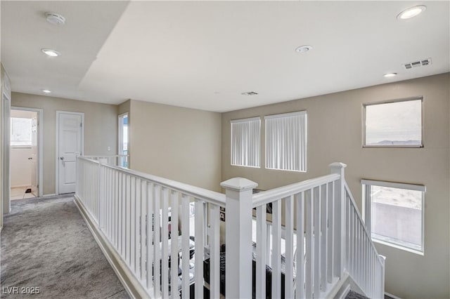 hallway featuring visible vents, an upstairs landing, recessed lighting, carpet, and a healthy amount of sunlight