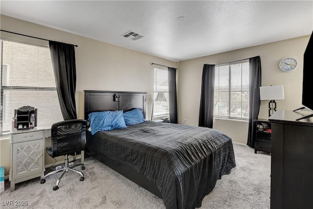 bedroom featuring visible vents and light carpet