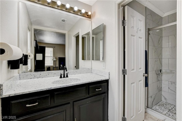 full bath with vanity, crown molding, visible vents, and a stall shower