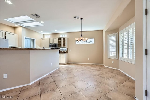 2715 Riceville Dr, Henderson, NV 89052 - kitchen with stainless steel microwave, recessed lighting, glass insert cabinets, a chandelier, and pendant lighting