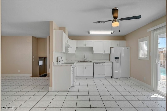 kitchen featuring white appliances, light tile patterned floors, white cabinets, light countertops, and a sink