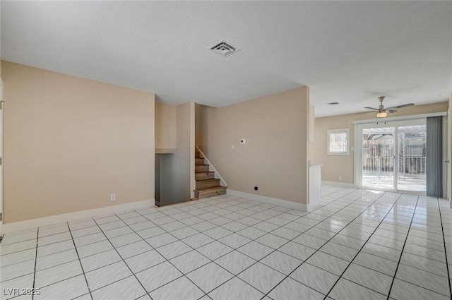 spare room featuring baseboards, visible vents, ceiling fan, stairs, and light tile patterned flooring