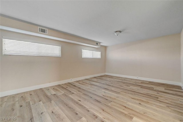 unfurnished room with visible vents, baseboards, and wood finished floors