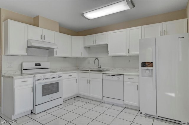 kitchen featuring white appliances, decorative backsplash, under cabinet range hood, white cabinetry, and a sink