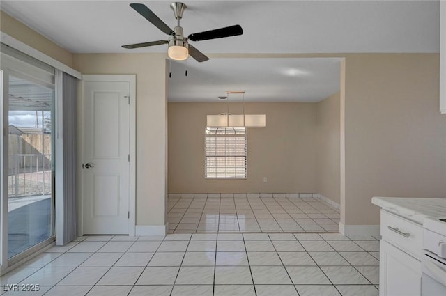 spare room with ceiling fan, baseboards, and light tile patterned flooring