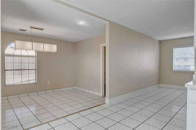 spare room featuring light tile patterned floors, baseboards, and visible vents