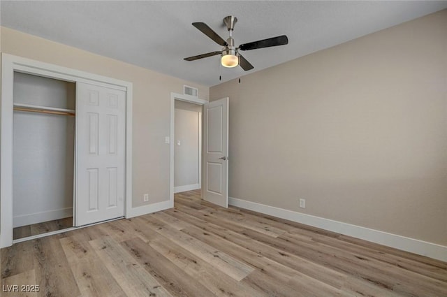 unfurnished bedroom with light wood finished floors, a closet, visible vents, ceiling fan, and baseboards