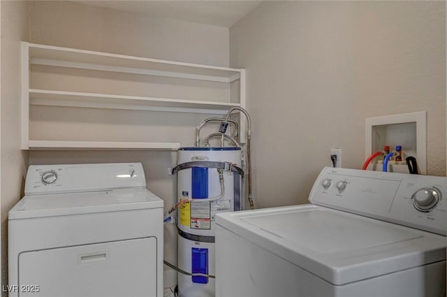 laundry area with strapped water heater, laundry area, and washer and dryer