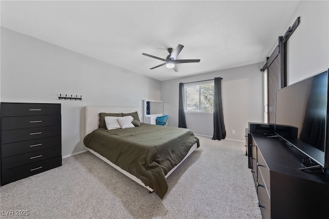 bedroom with light carpet, a barn door, a ceiling fan, and baseboards