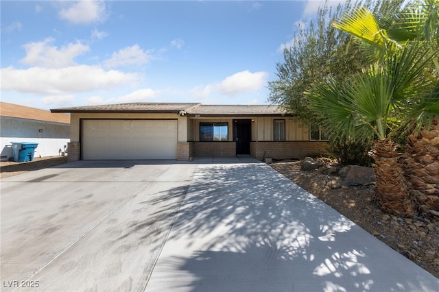 single story home featuring an attached garage, board and batten siding, concrete driveway, and brick siding