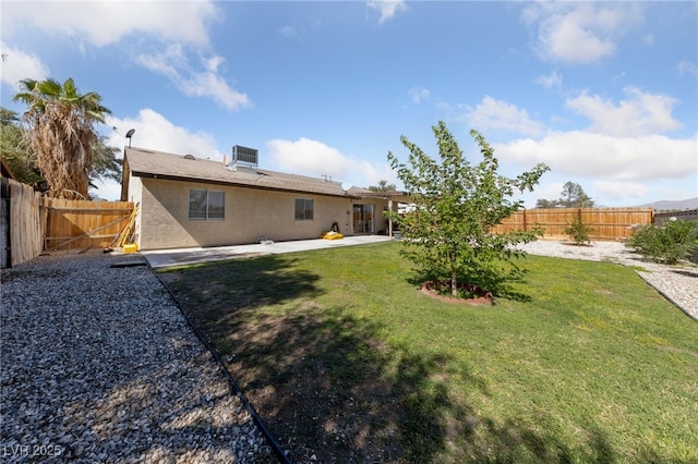 rear view of property featuring a patio, central AC unit, a fenced backyard, a lawn, and stucco siding