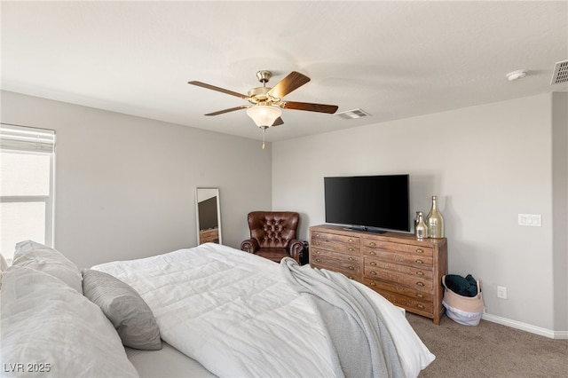 carpeted bedroom featuring a ceiling fan, visible vents, and baseboards