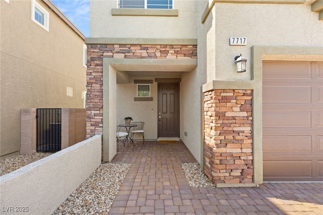 view of exterior entry featuring stone siding and stucco siding