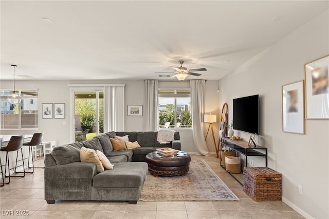 living room with a healthy amount of sunlight, baseboards, and light tile patterned floors