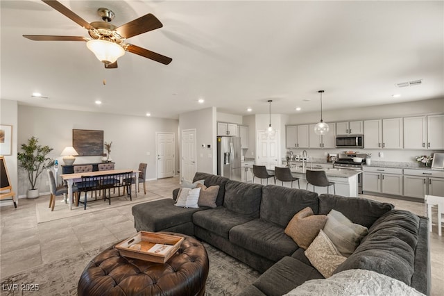 living room featuring baseboards, visible vents, and recessed lighting