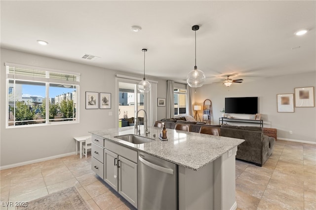 kitchen featuring visible vents, dishwasher, light stone countertops, pendant lighting, and a sink