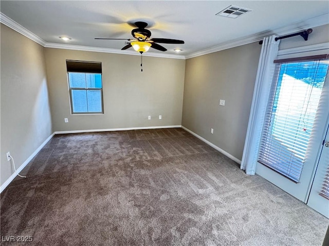 empty room featuring a wealth of natural light, carpet, visible vents, and crown molding