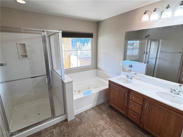 full bath with a sink, a shower stall, a tub with jets, and double vanity